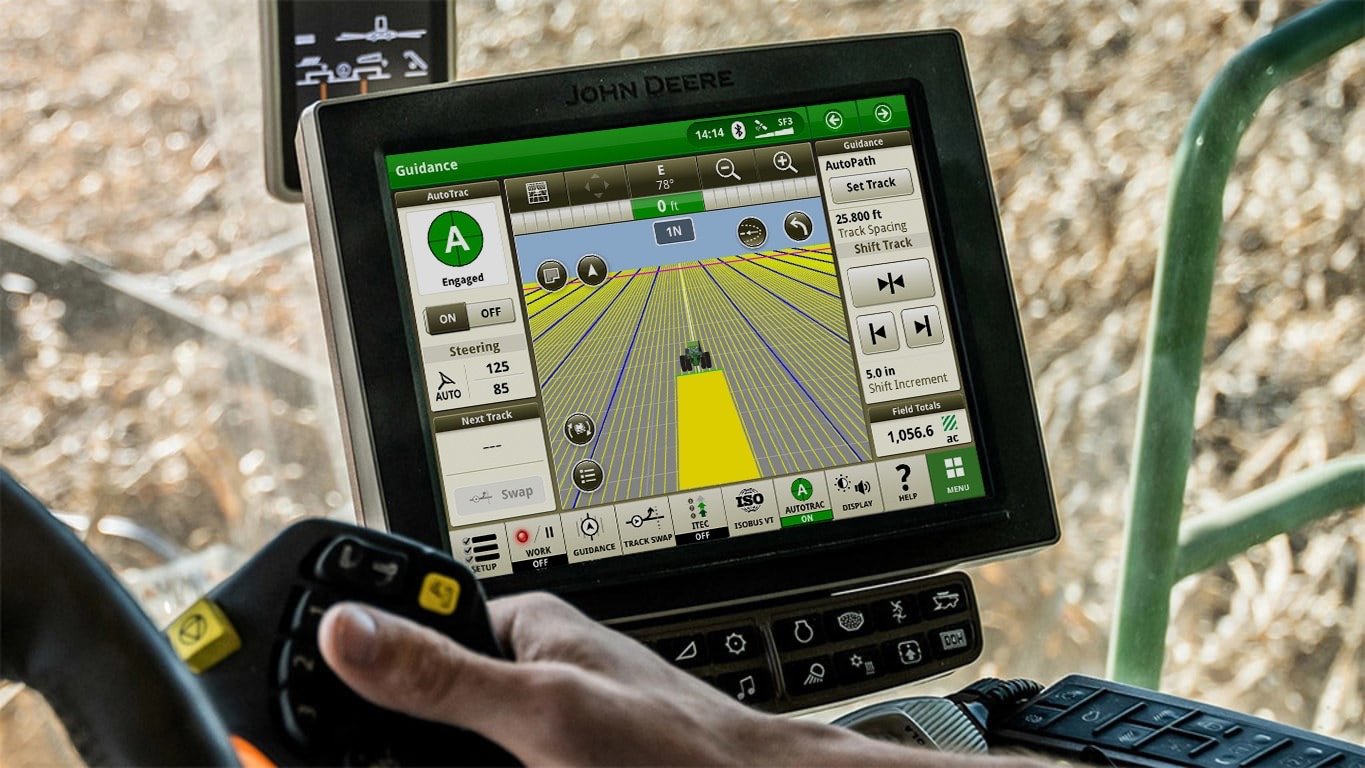 John Deere GreenStar display with AutoTrac engaged, showing guidance lines across a field